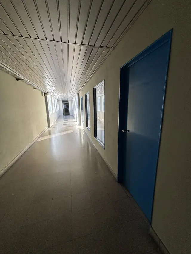 Pasillo de planta industrial con paredes y puertas recién pintadas